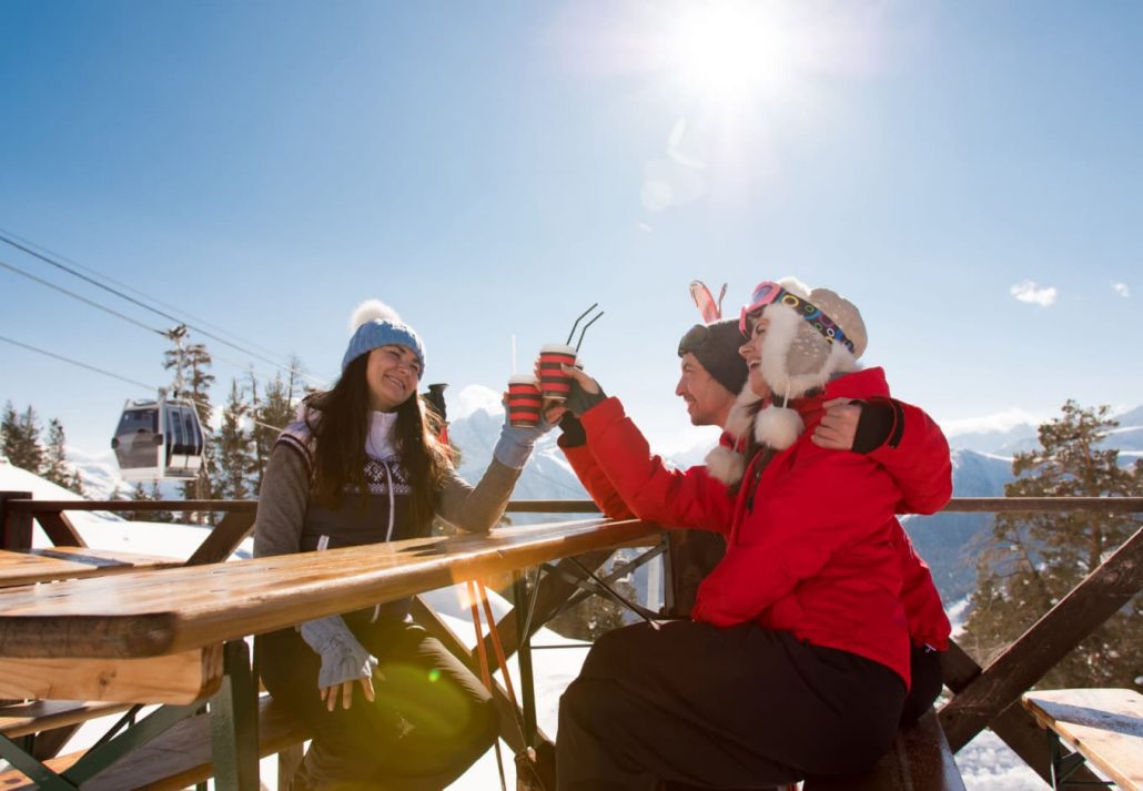A group of friends having a drink at the top of the ski center