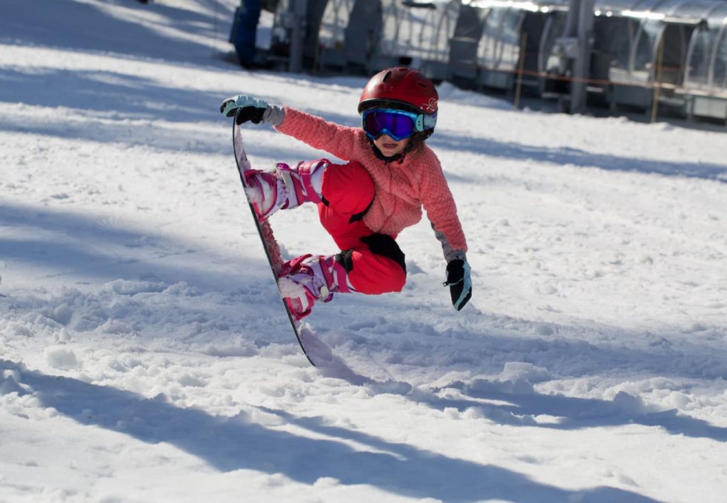 skiing-in-greece-4 | CuddlyNest Travel Blog A little girl jumping on a snowboard