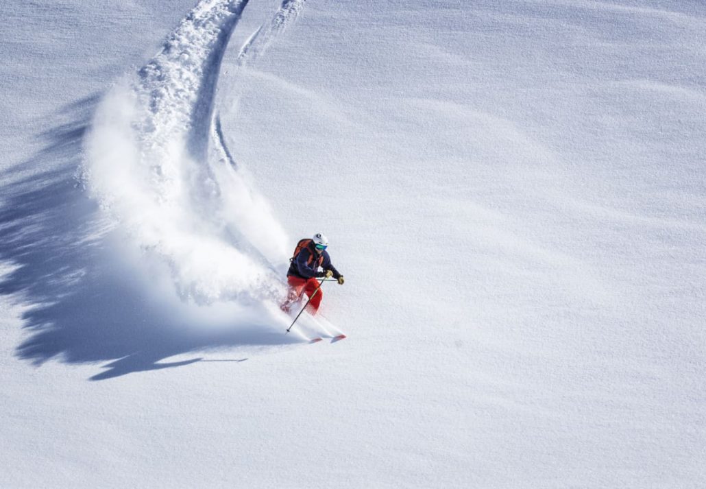 A man skiing fast down a hill