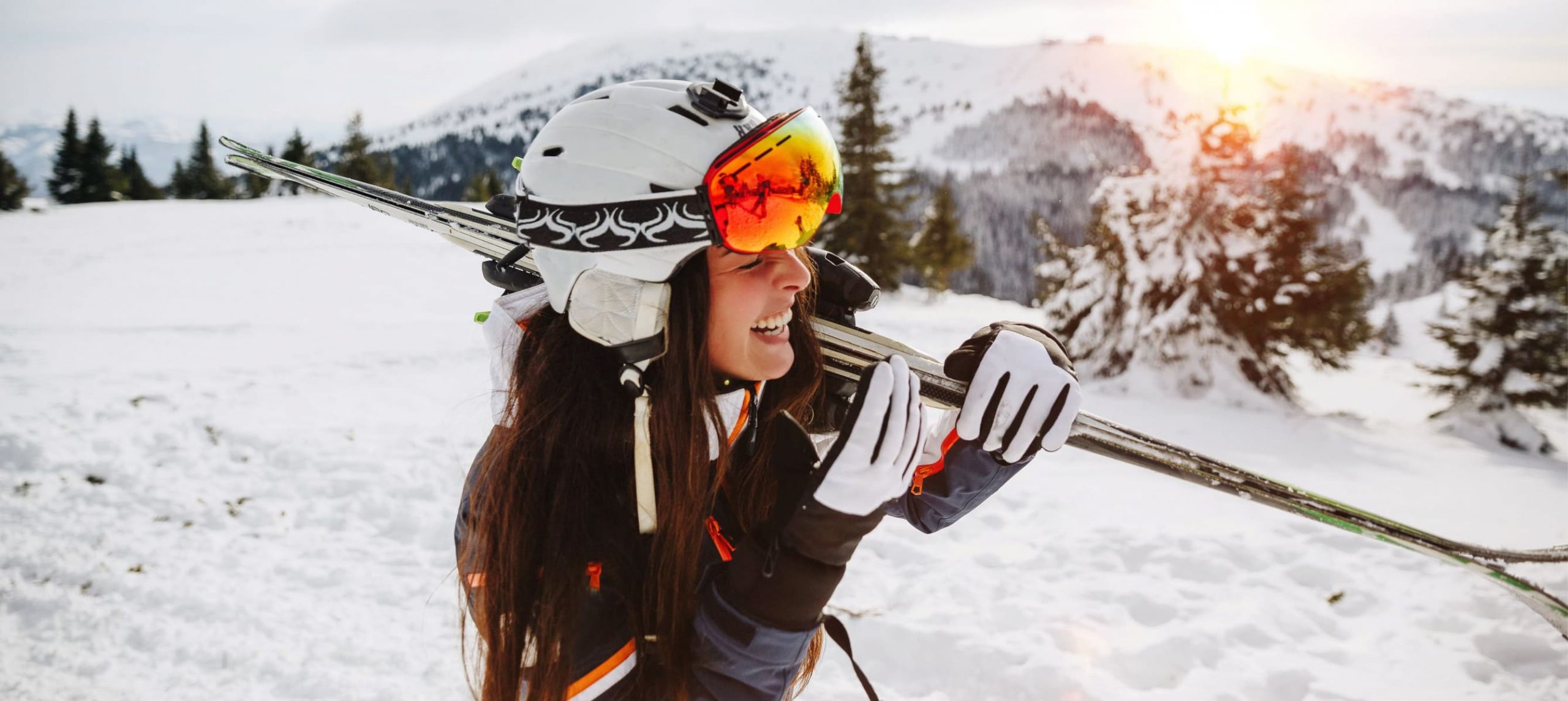 A girl dressed in a ski suit smiling for a photo