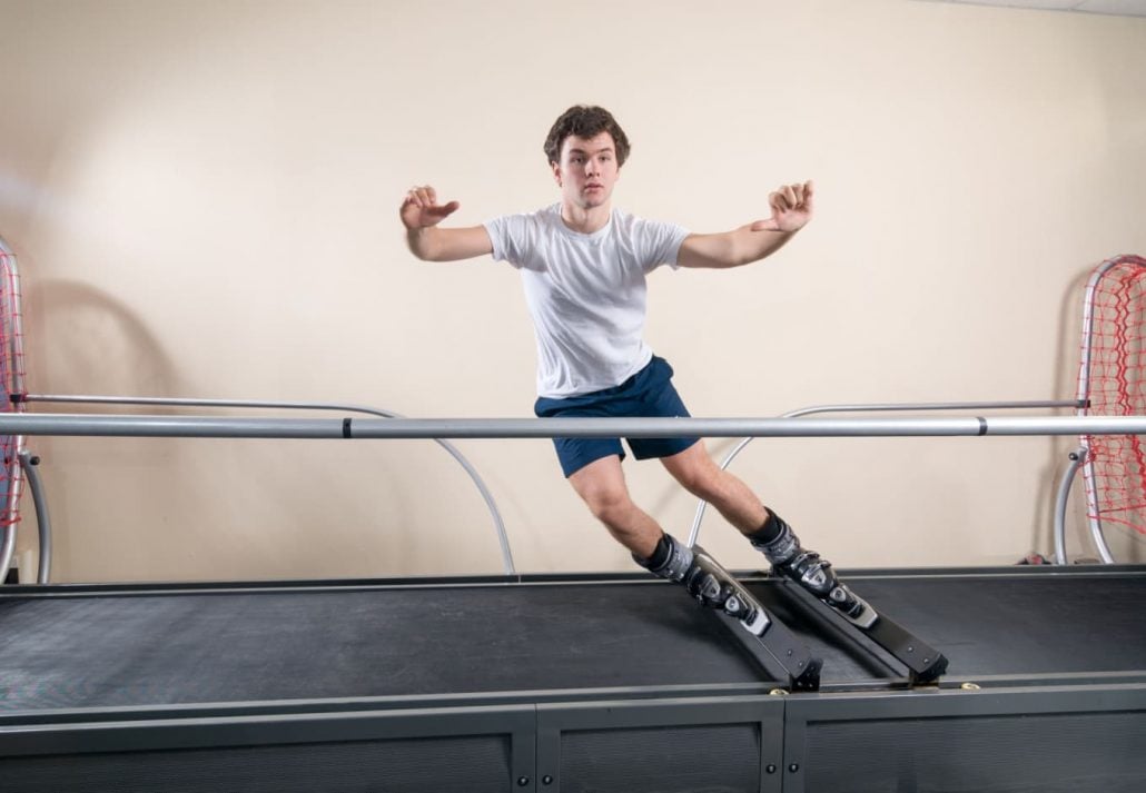 Young man training on a skiing simulator.