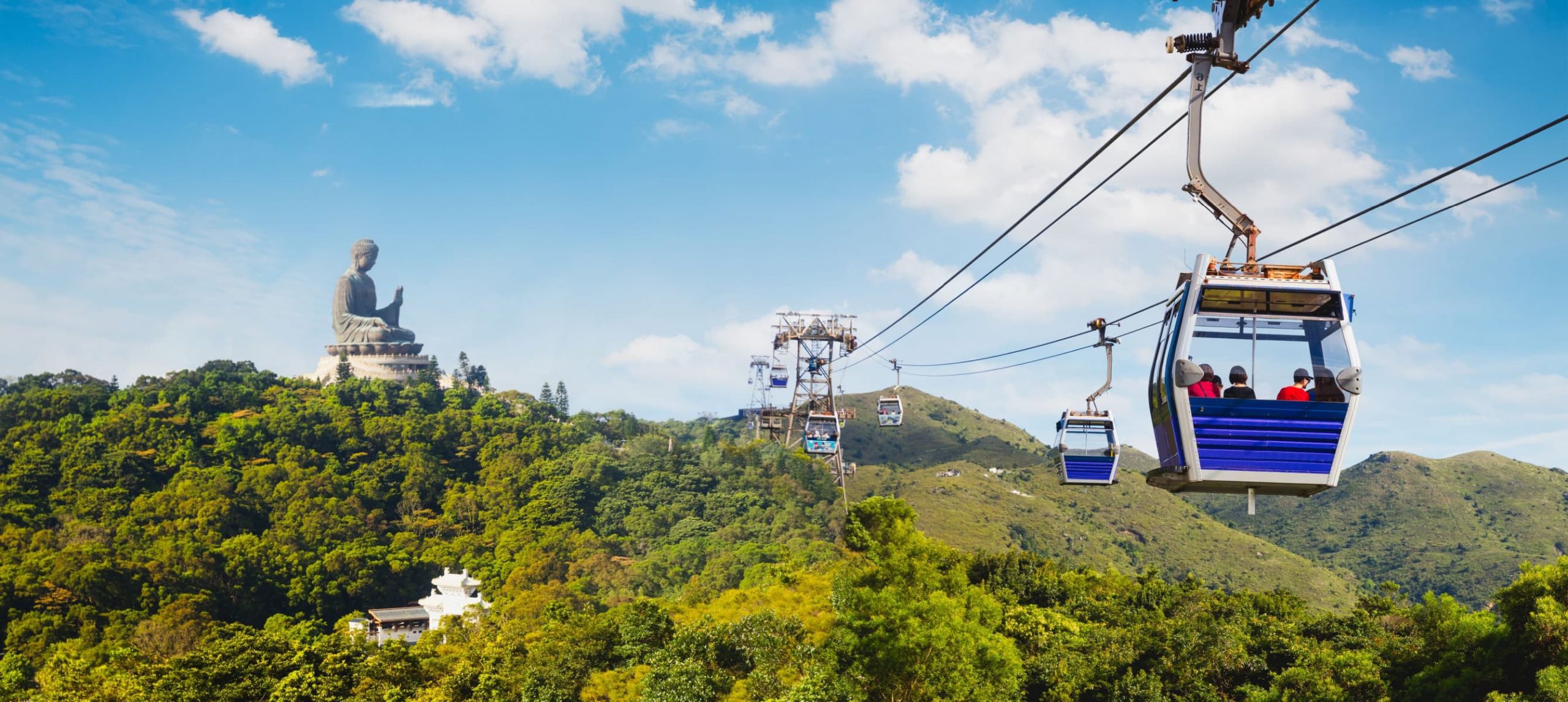 Ngong Ping cable car and the Big Buddha on the back, in Lantau Island, Hong Kong.