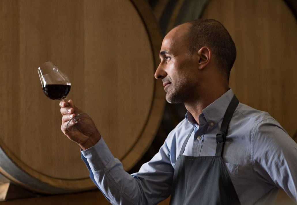 A bartender admiring a glass of wine