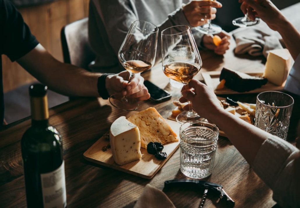A wine bar table with wines and cheese