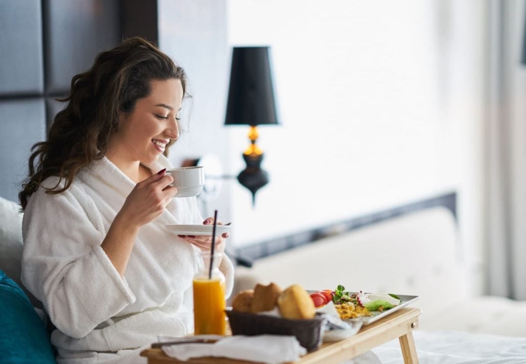 Woman drinking coffee in a hotel room