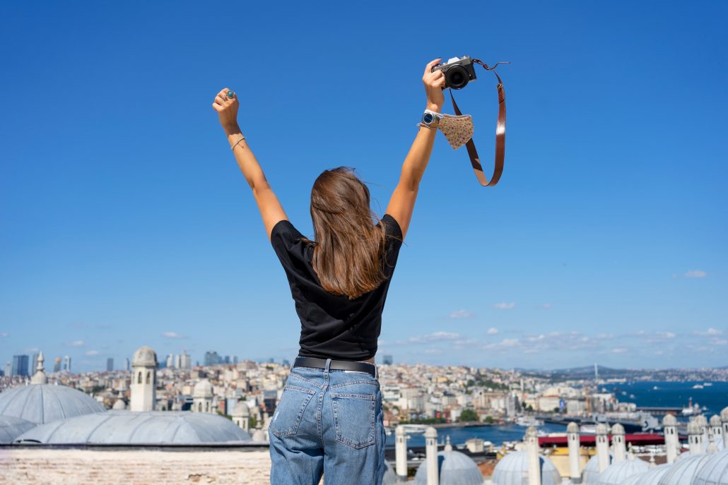 A woman standing on the rooftop terrace, facing the view of Istanbul