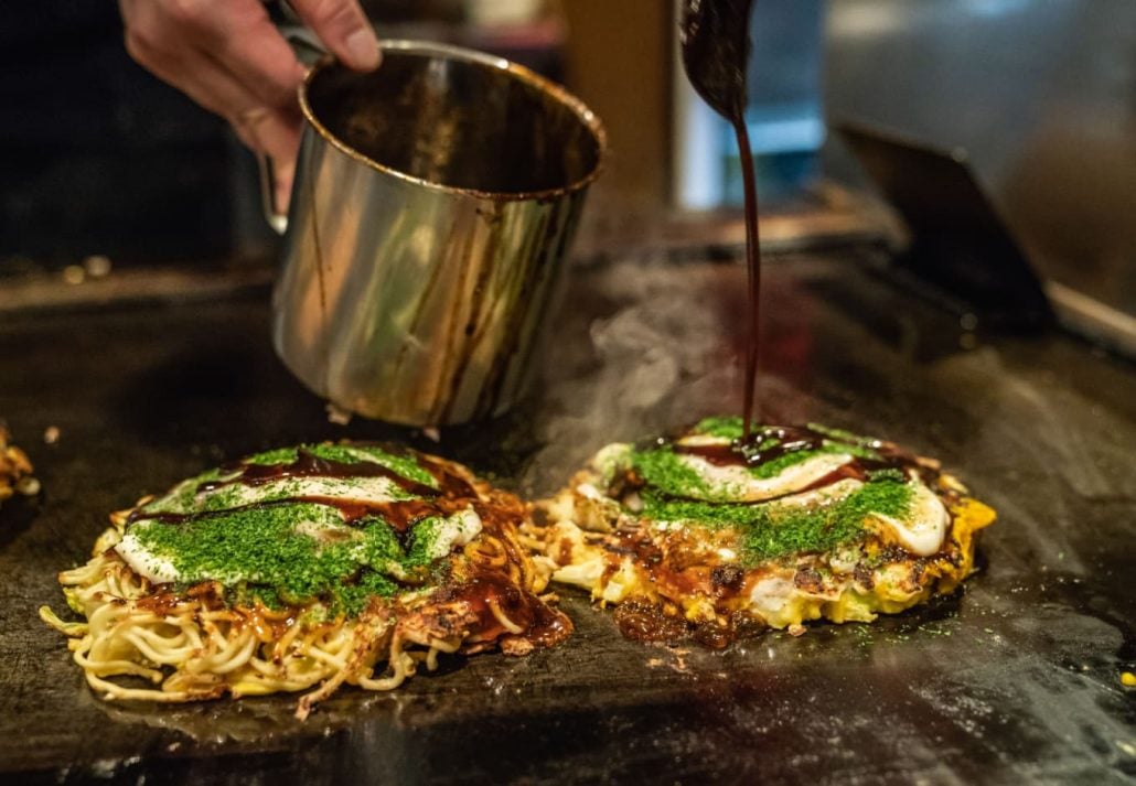 Chef pouring sauce over a dish