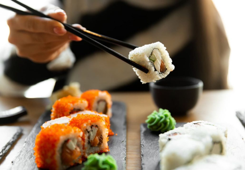 A girl taking sushi from a plate