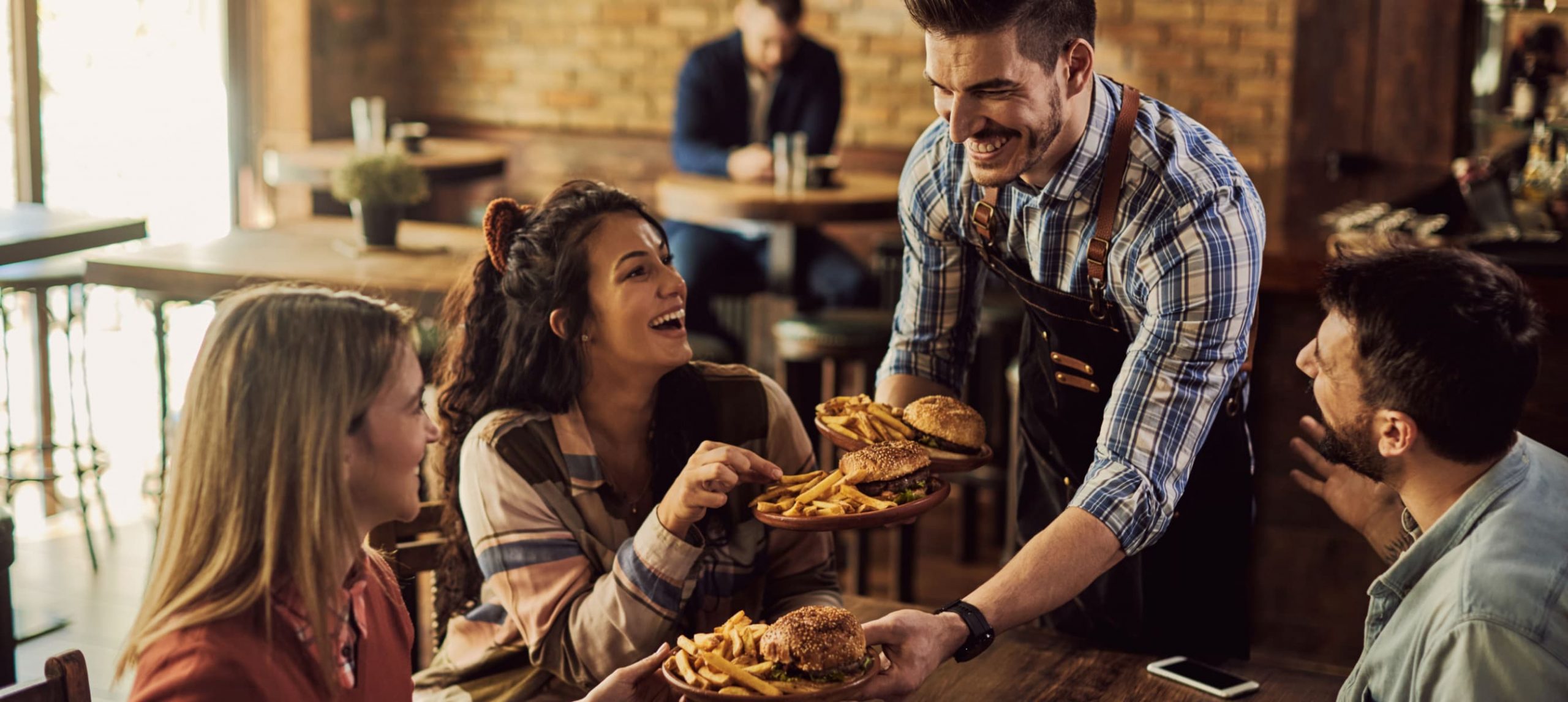 a waiter brining food to guests