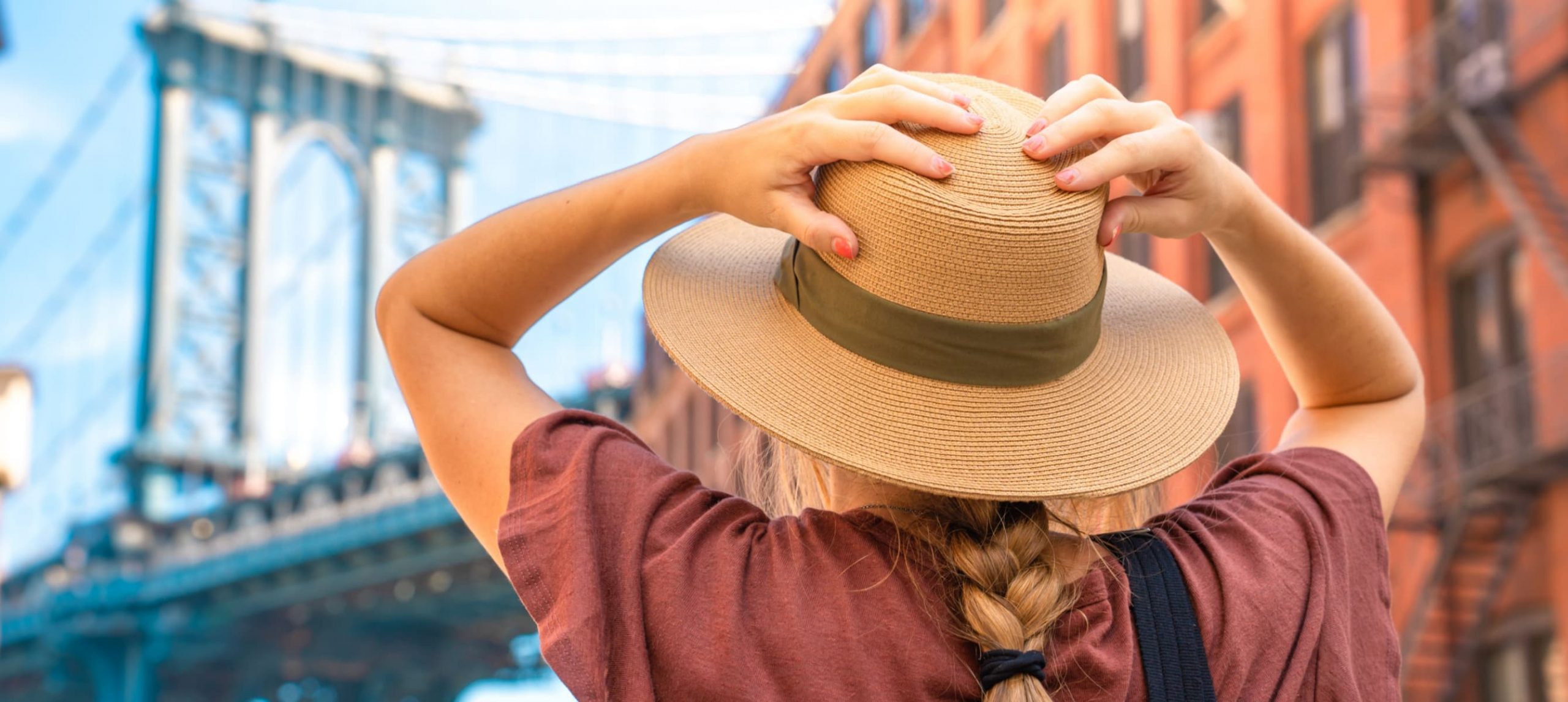 A young woman gazing at New York's Brooklyn Bridge.