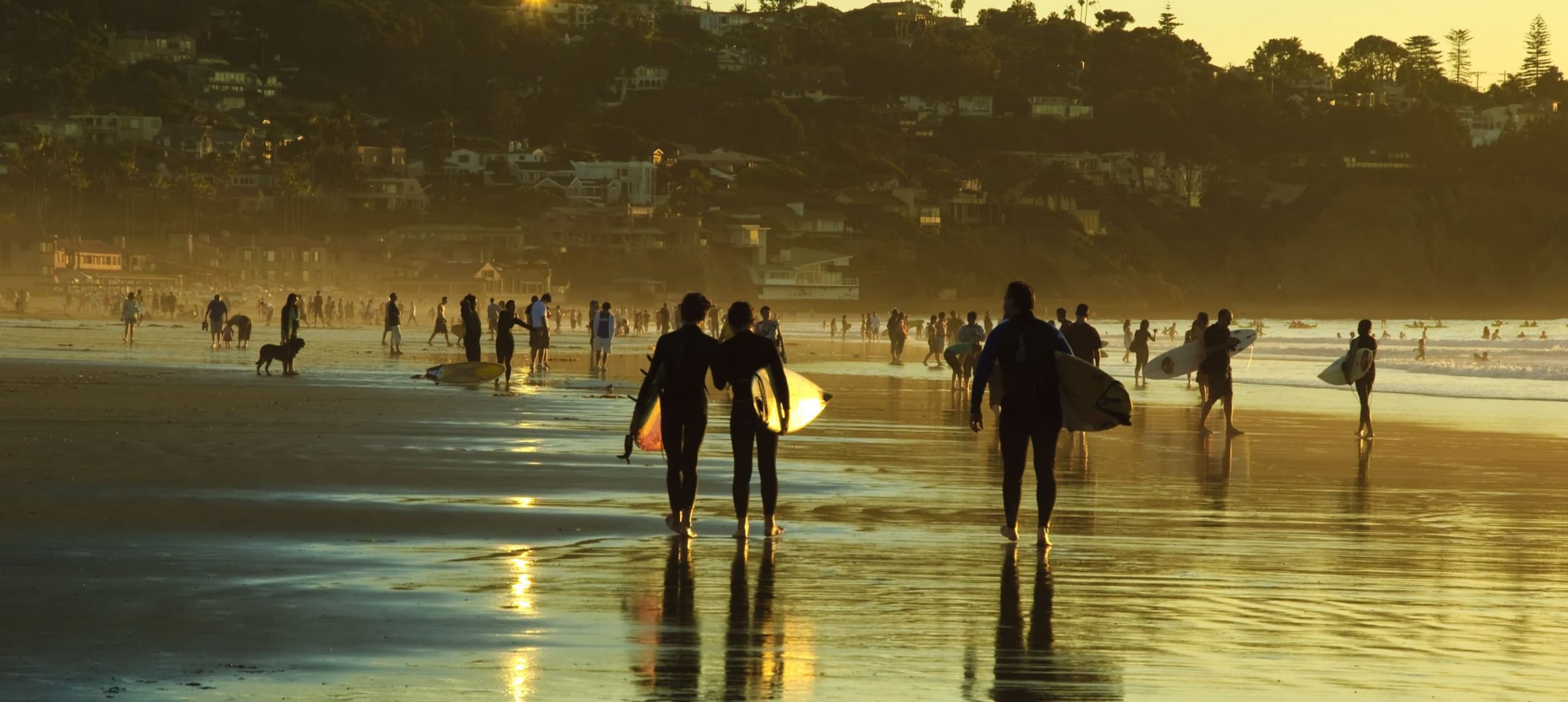 Surfer walking in the La Jolla beach in San Diego, California.