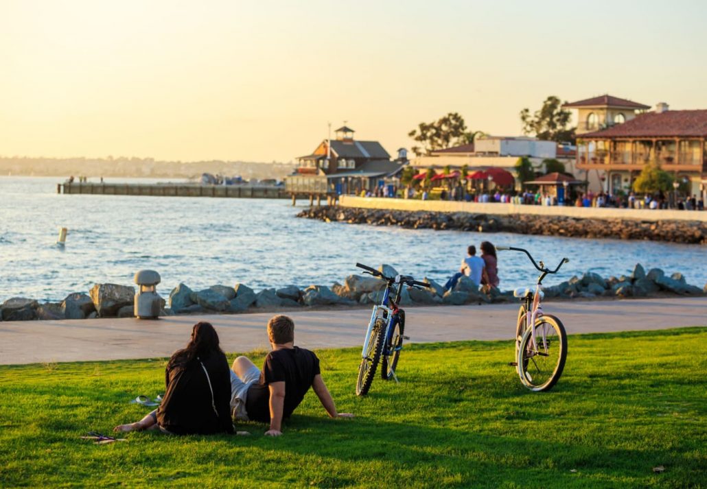 A couple sitting on the grass in San Diego's Waterfront Public Park.