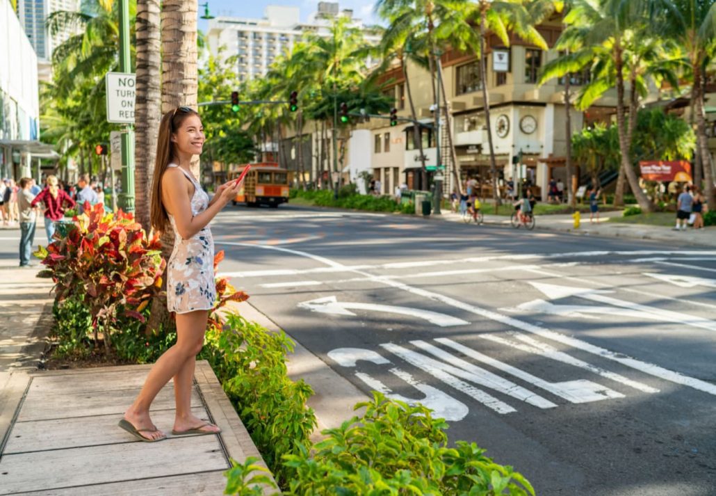 A girl waiting to walk across the street in Honolulu