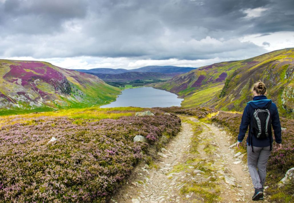 Tourist walking down from Cairn Lick to Loch Lee, Cairngorms National Park, Scotland.