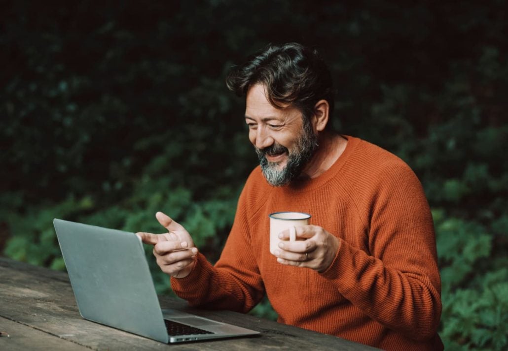 a man working on the laptop at a park