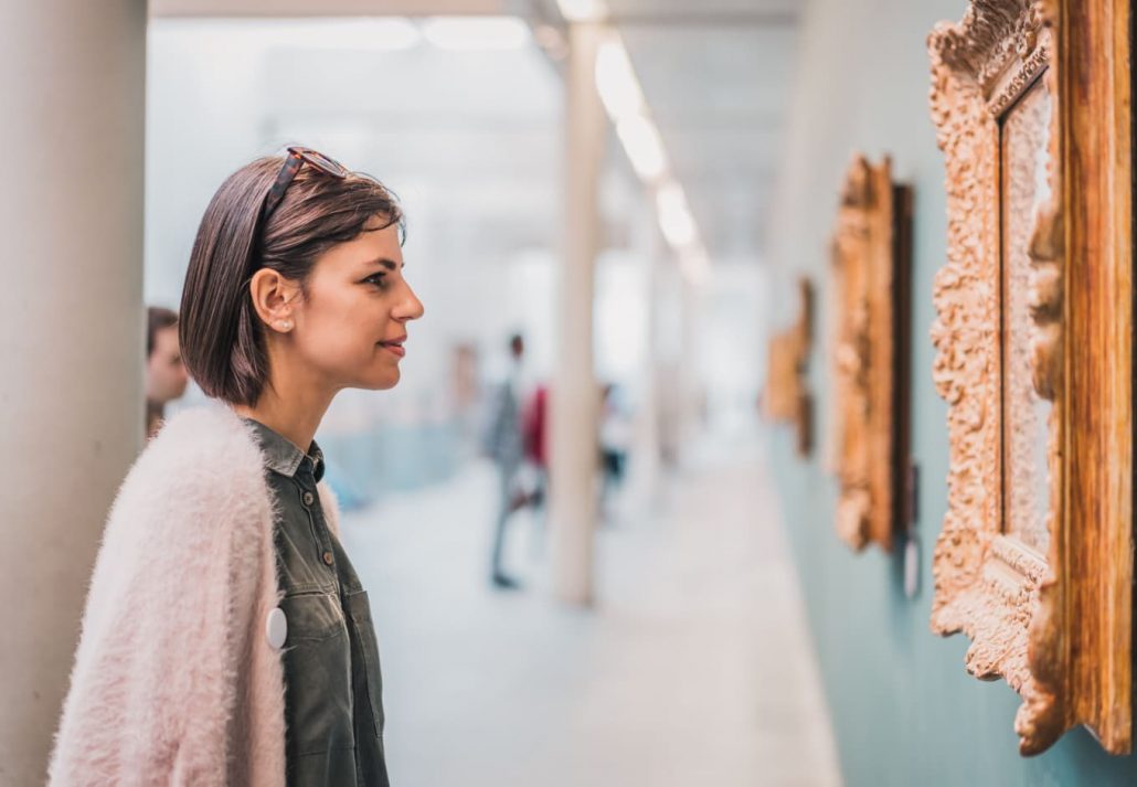 a woman looking at a painting in a museum