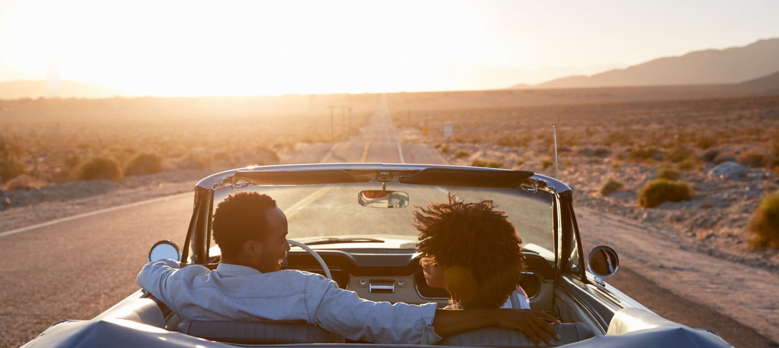 A couple happily going on a road trip during the afternoon.