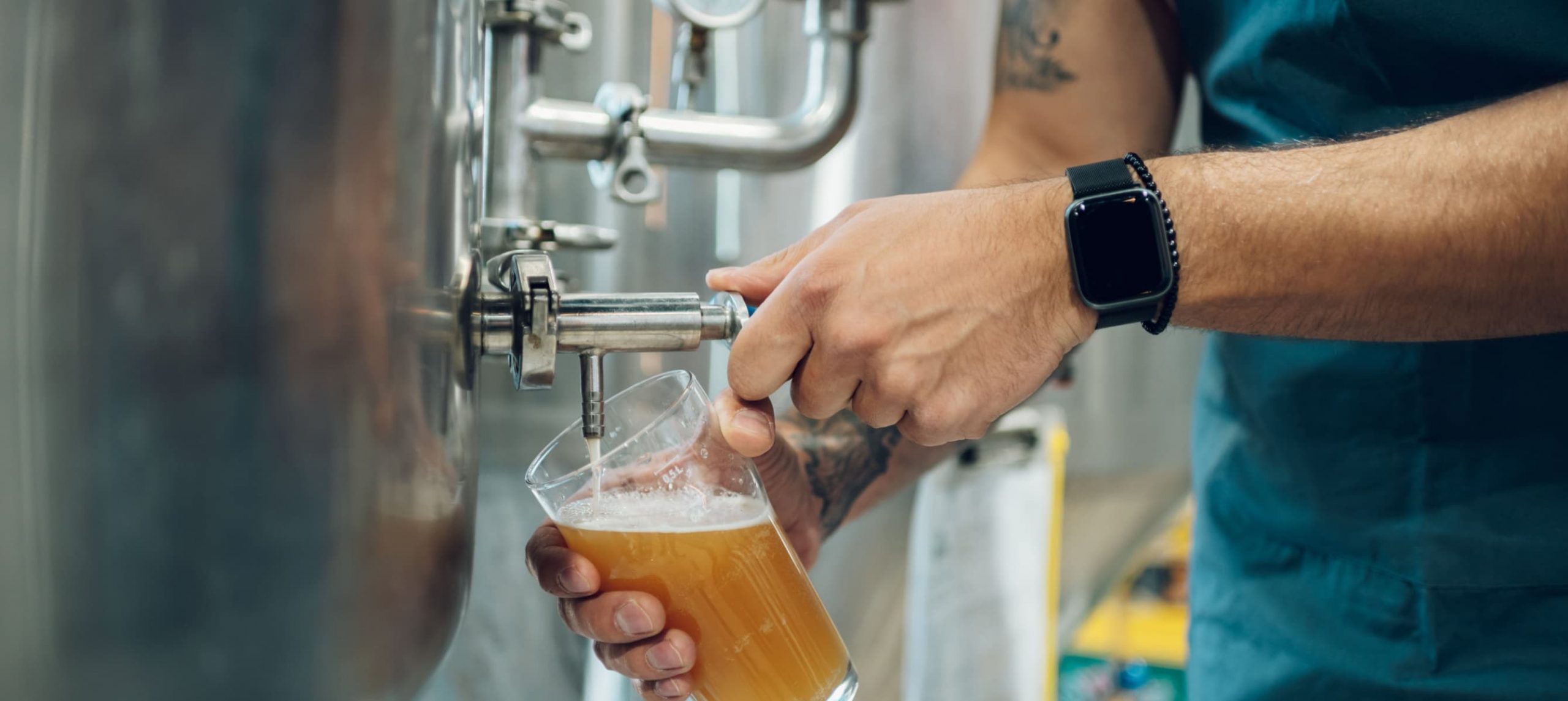 beer poured in a glass in a brewery