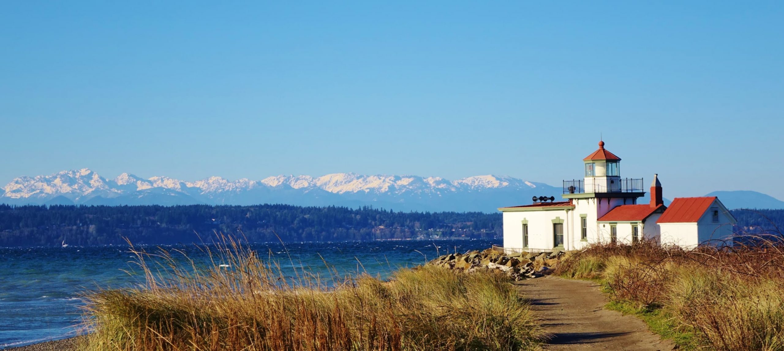 The West Point Lighthouse, situated at the midpoint of Discovery Park's 4.5-mile loop trail, offers an oceanic view of the Cascade and Olympic mountain ranges.