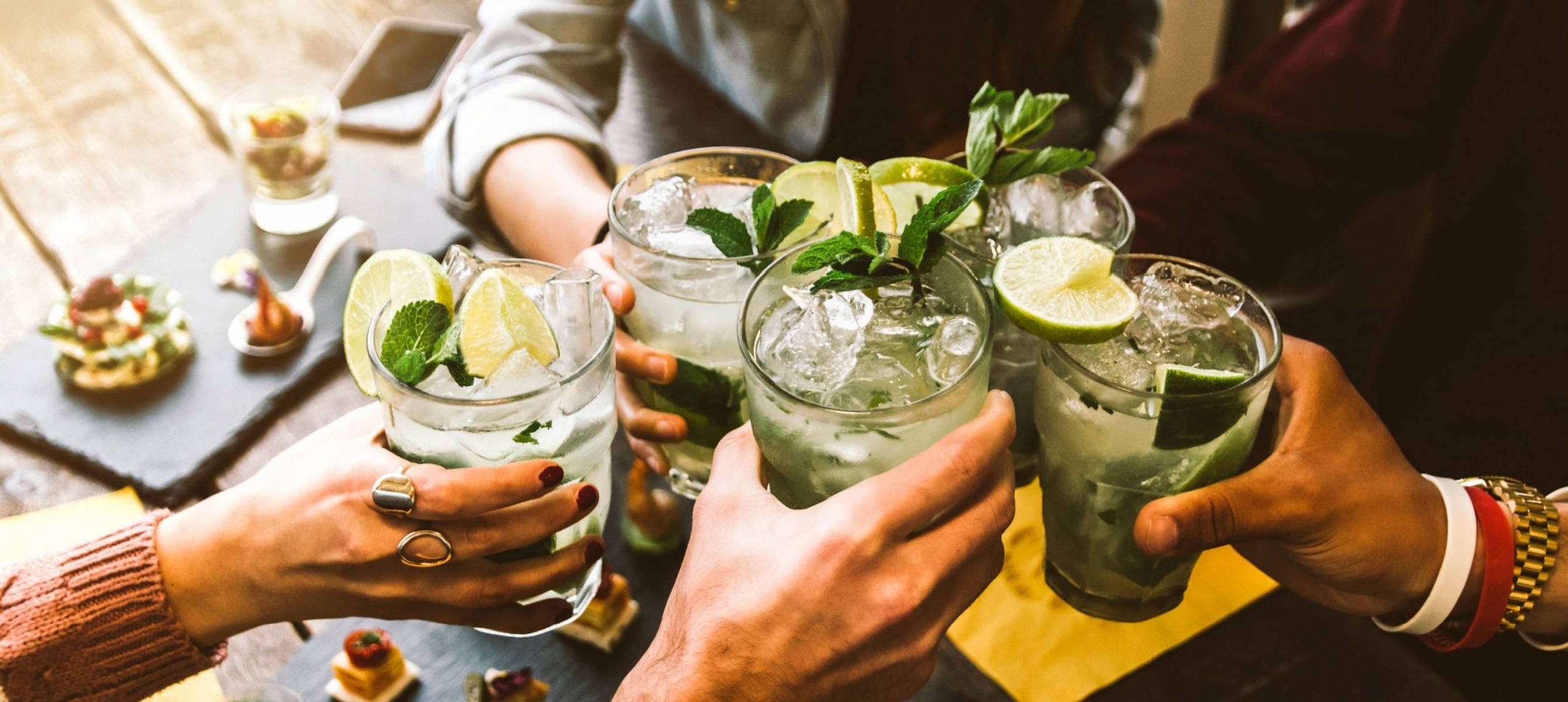 people holding drinks at a bar