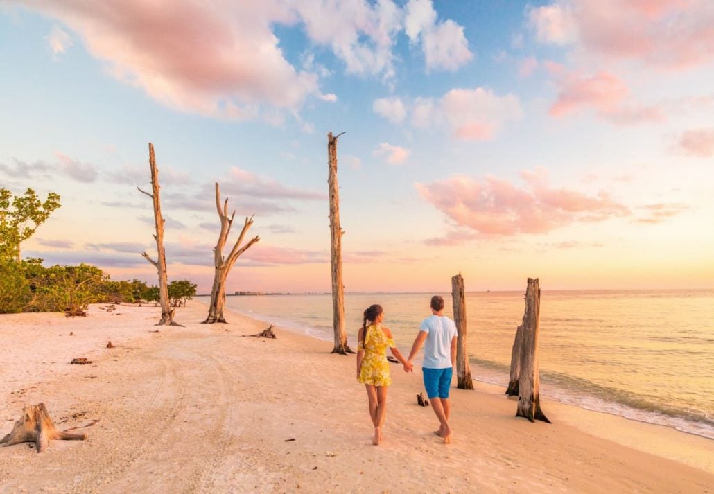 Couple holding hands waling at Lovers Key State Park & Beach, Florida, USA.