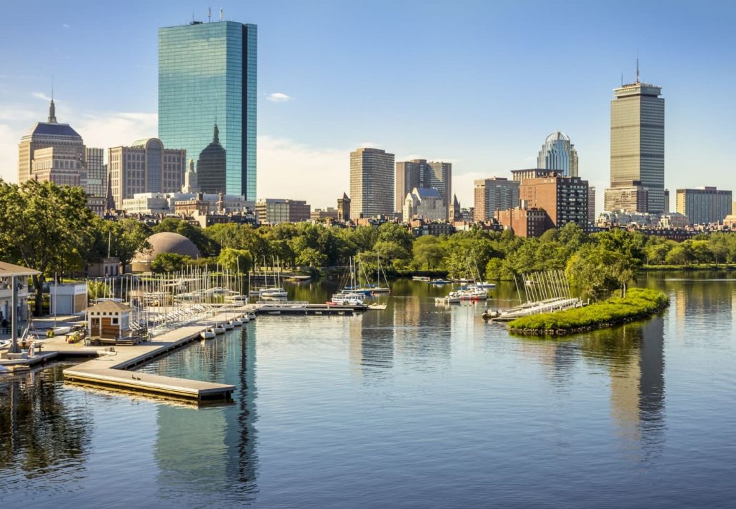 Panoramic view of Boston in Massachusetts, USA showcasing its mix of modern and historic architecture and the famous Charles River that crosses the city on a hot summer day.