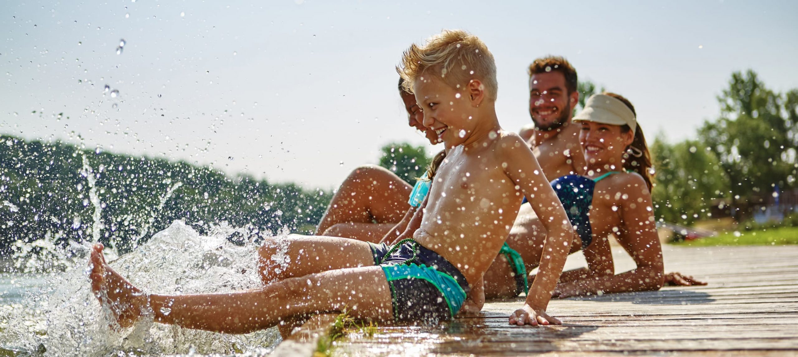 A happy family having fun in a lake during the summer.