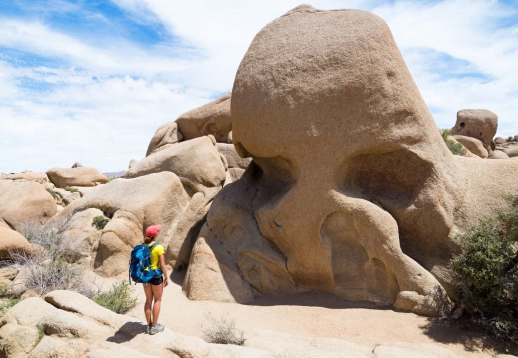 Hiker marveling at the Skull Rock, in the Joshua Tree National Park, California, USA.