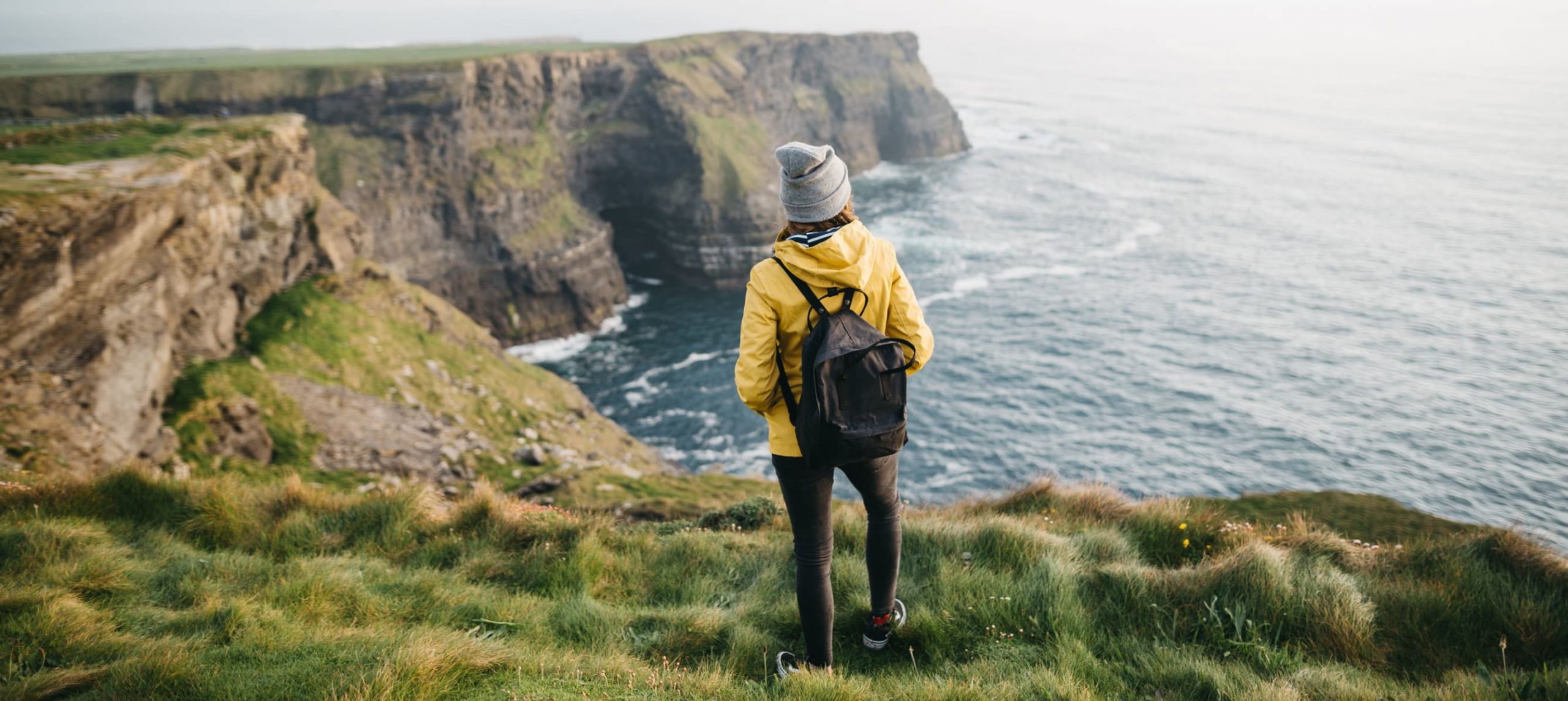 Young woman traveler in the Cliffs of Moher, Ireland, UK.