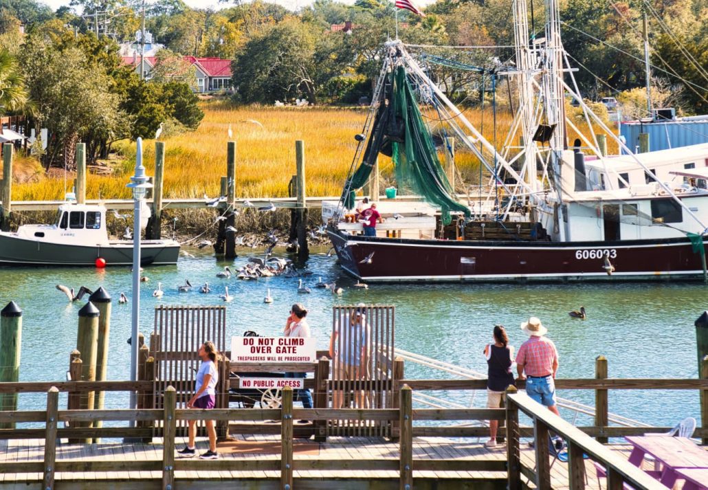 Boats on river a long boardwalk swamps and people, in South Carolina, USA.
