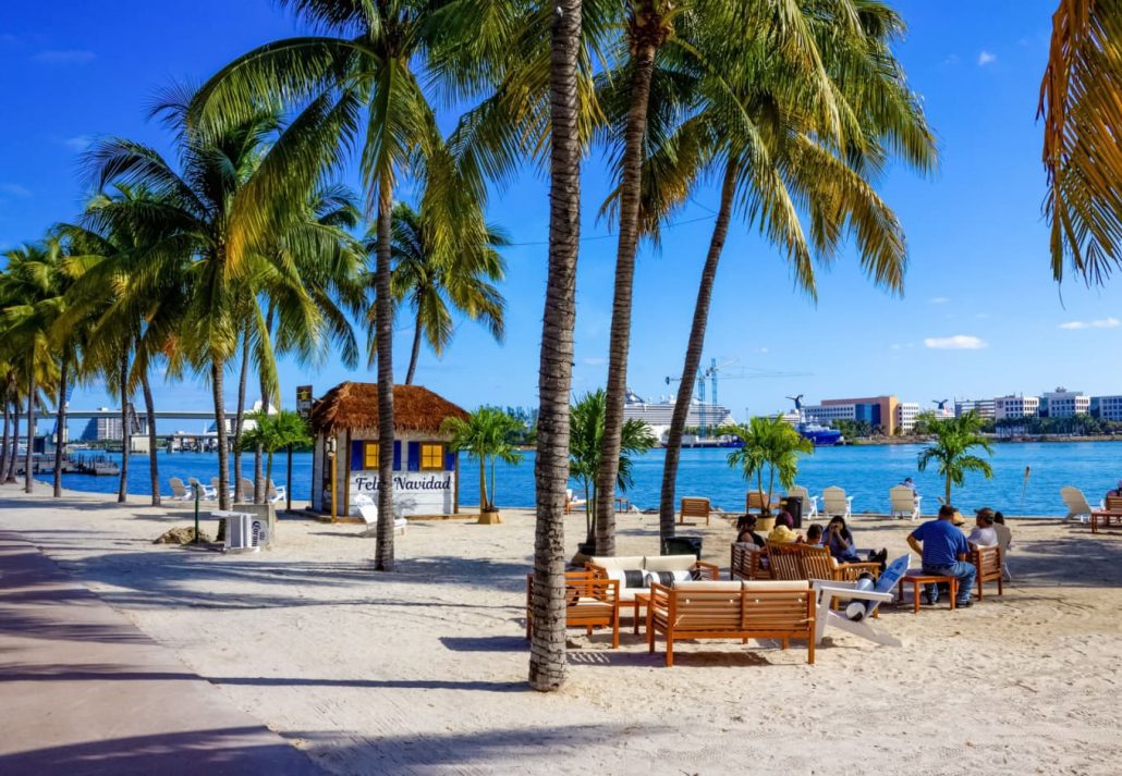 things-to-do-in-miami-bayfront-park | CuddlyNest Travel Blog People resting at Bayfront Park with palm trees in Miami, Florida, USA.