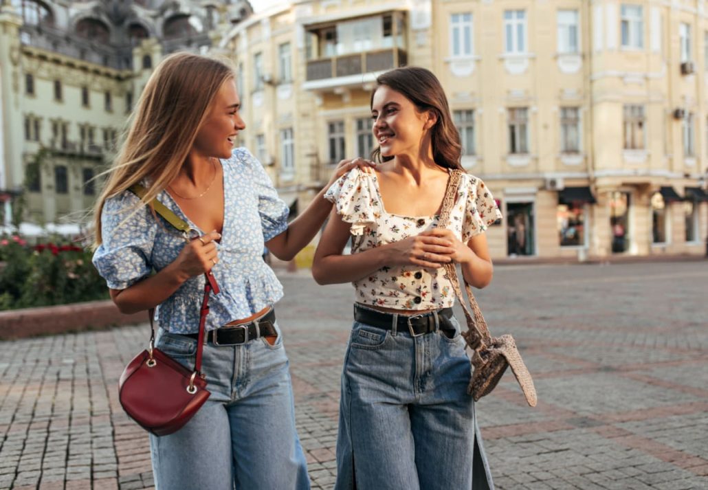 Two young tourist woman happily talking while walking around.