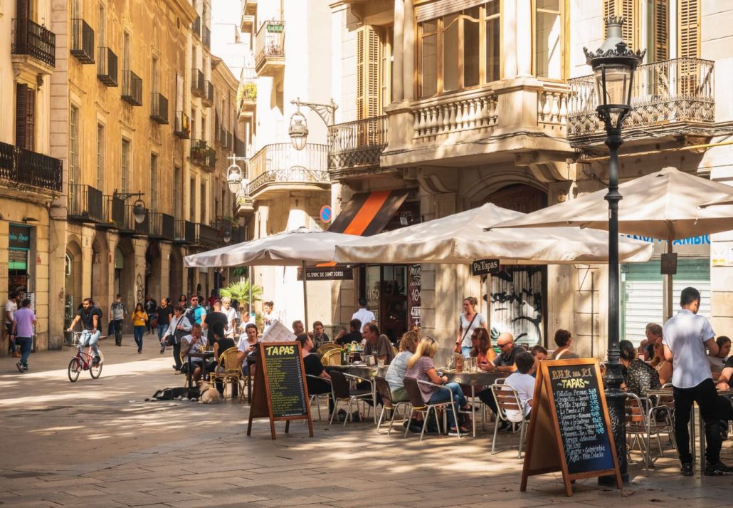 People sitting outdoor in a lively tapas restaurant in Barcelona, Spain.