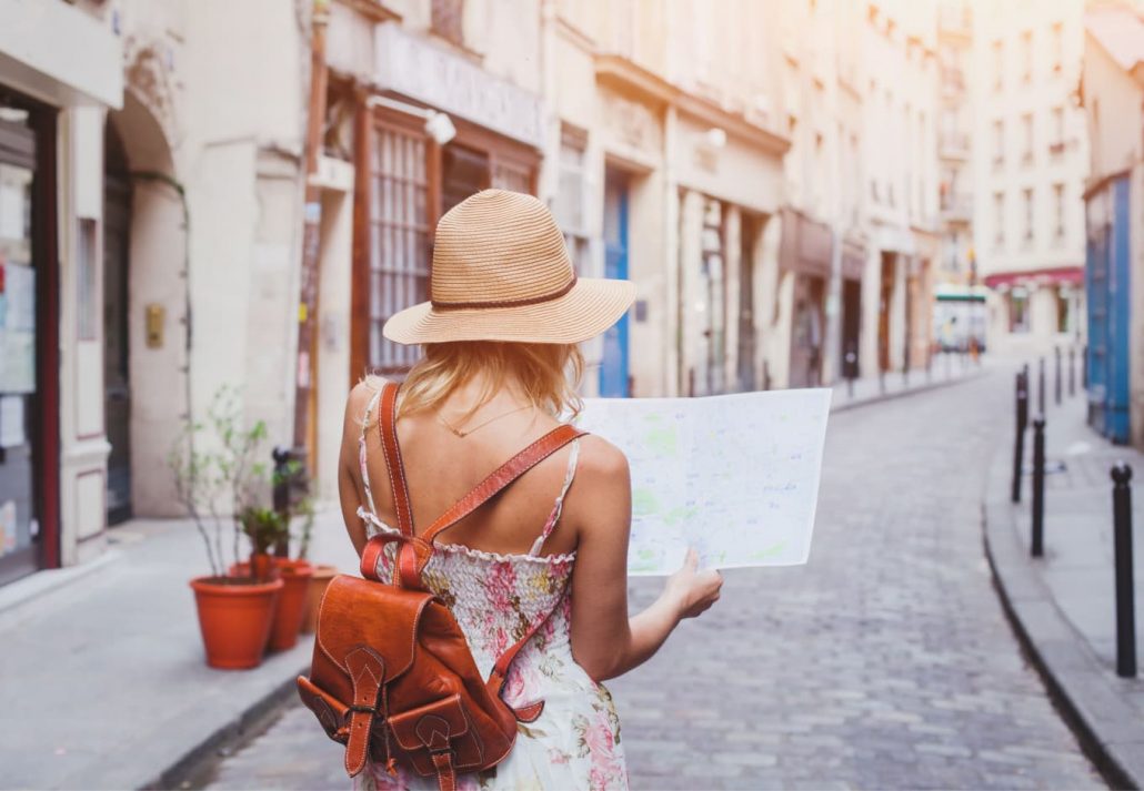 Young woman traveler holding a map while walking around in Barcelona.