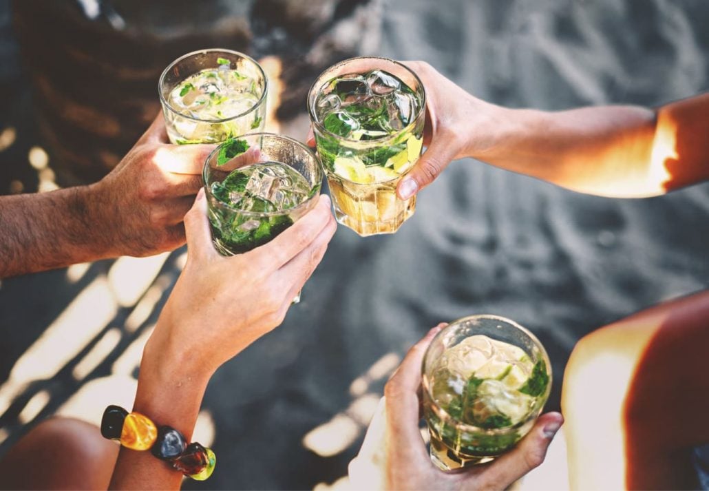 people holding glasses of mojitos