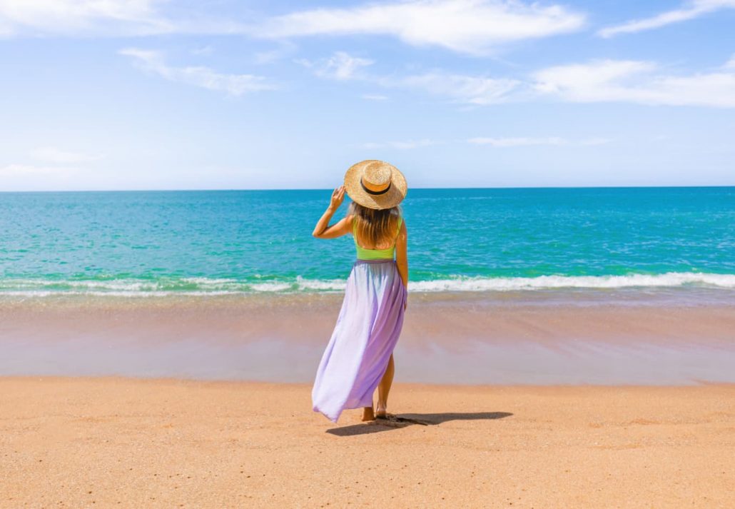 a woman walking on a sandy beach
