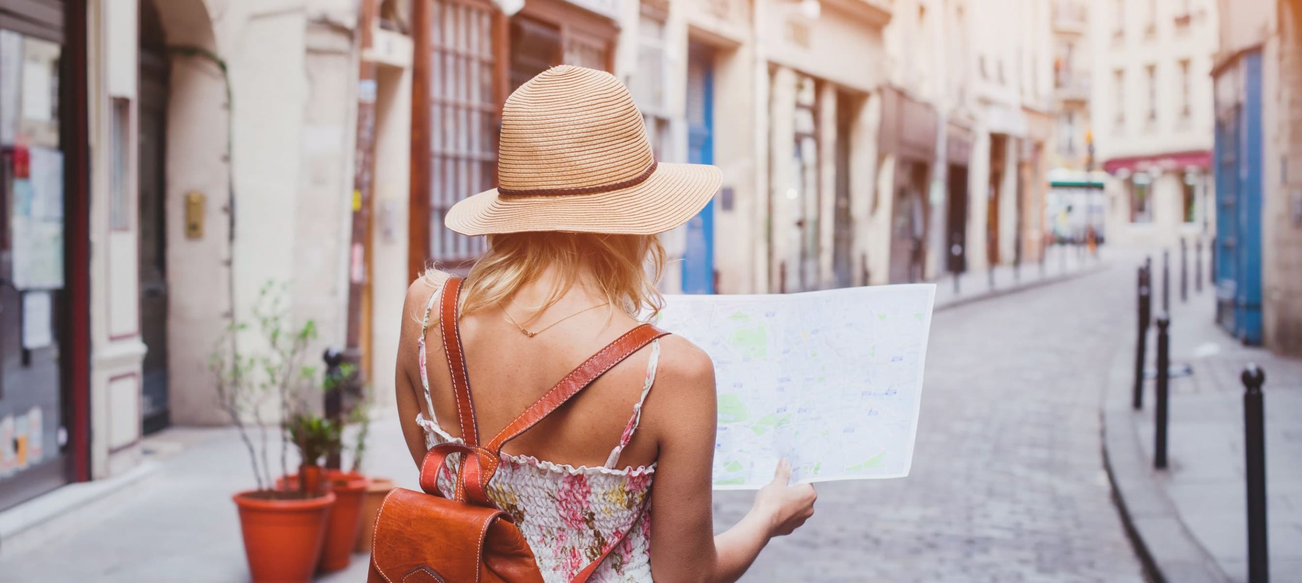 Young woman traveler holding a map while walking around in Barcelona.