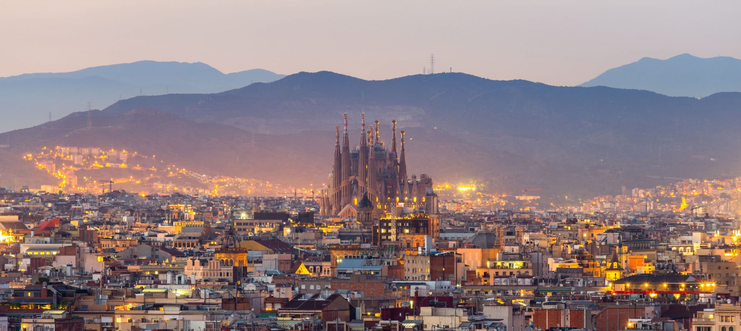 La Sagrada Familia and the Barcelona skyline at dawn.