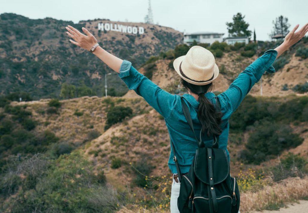 a woman looking at the Hollywood sign