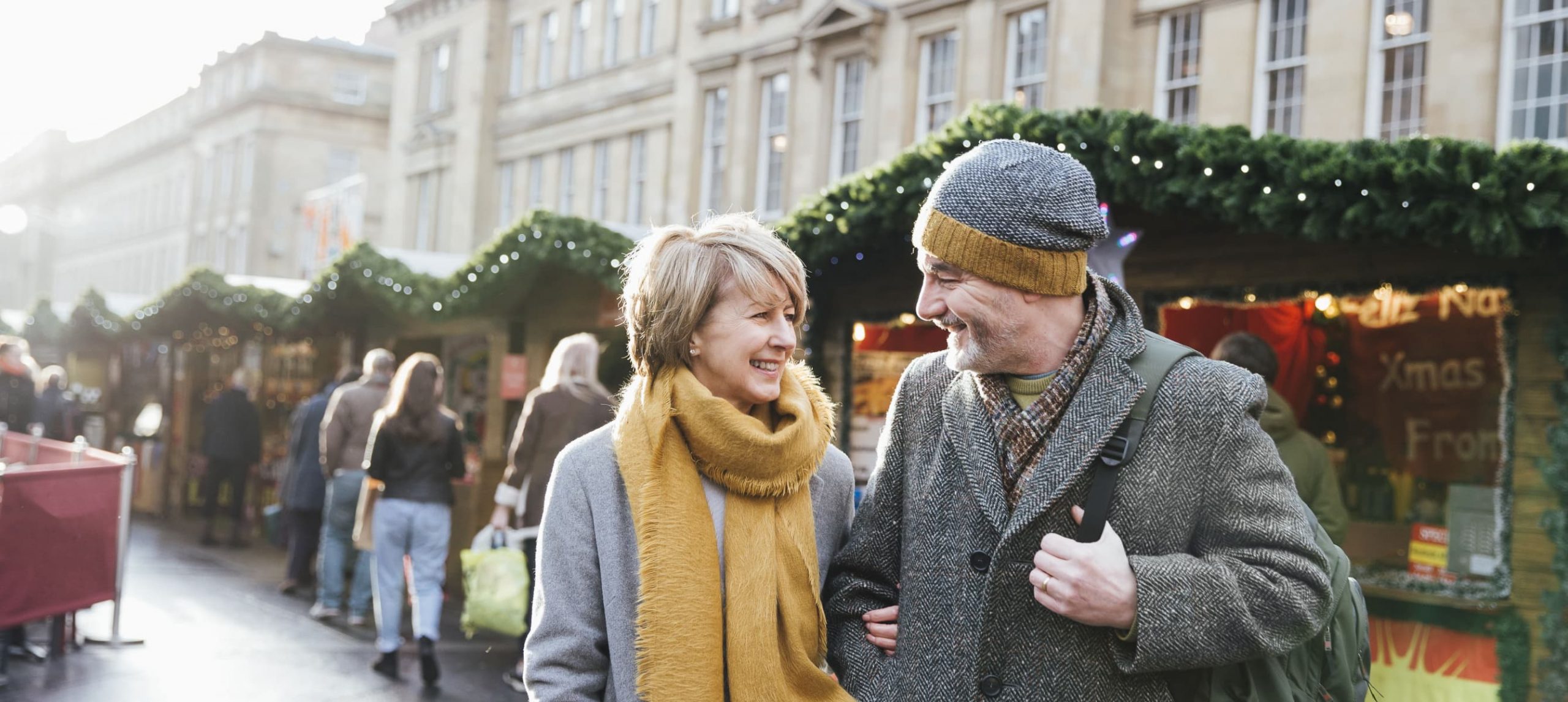 a couple standing in front of Christmas market stalls