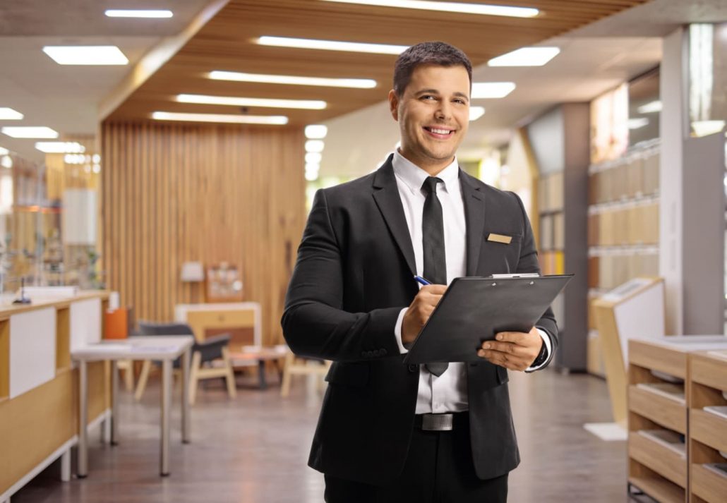 a hotel manager flashing a smile while standing in a hotel lobby