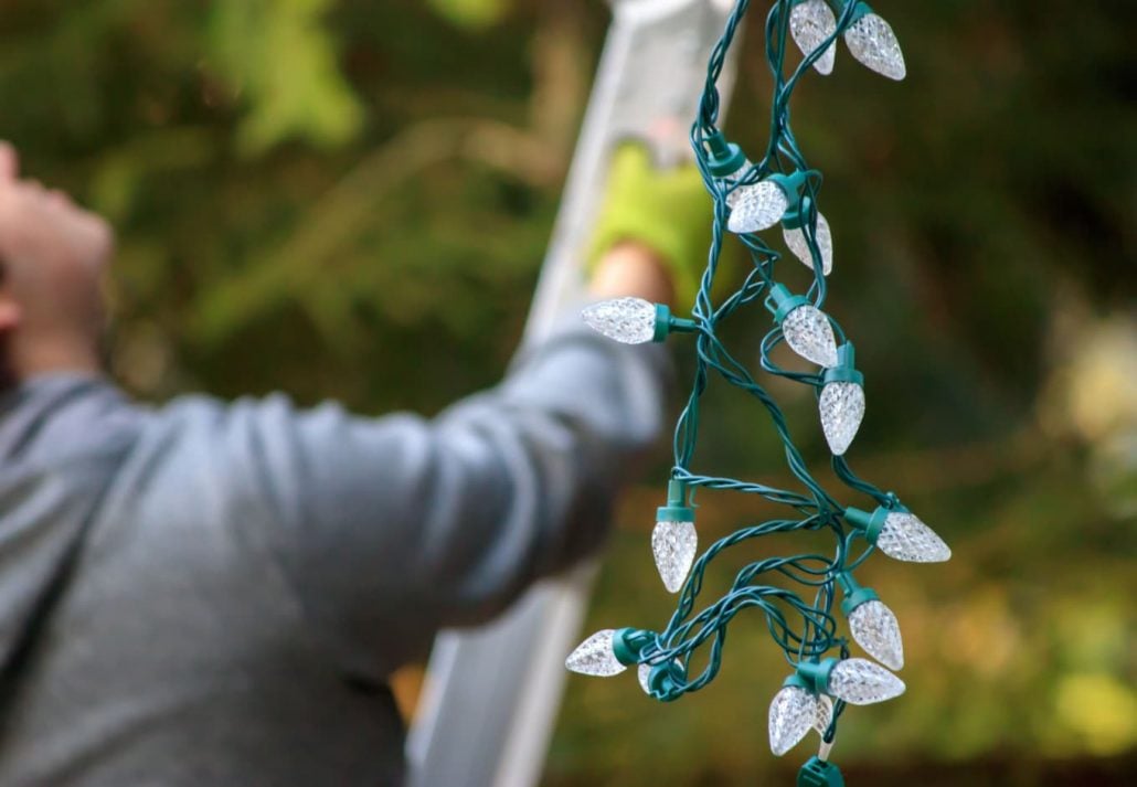a person hanging Christmas lights