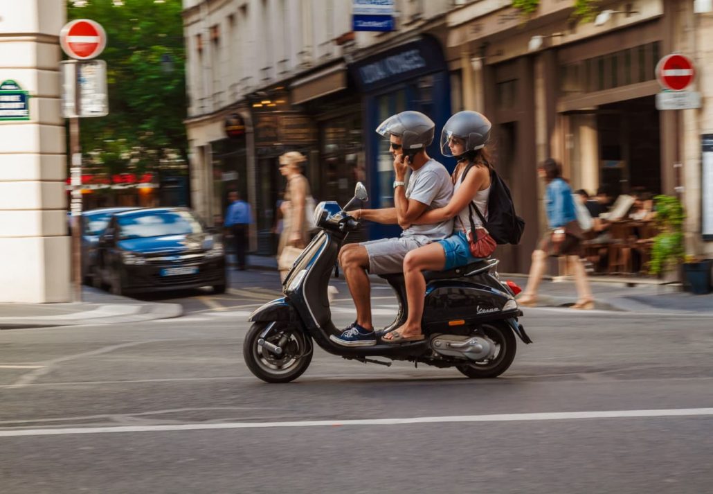 people riding a scooter in Paris