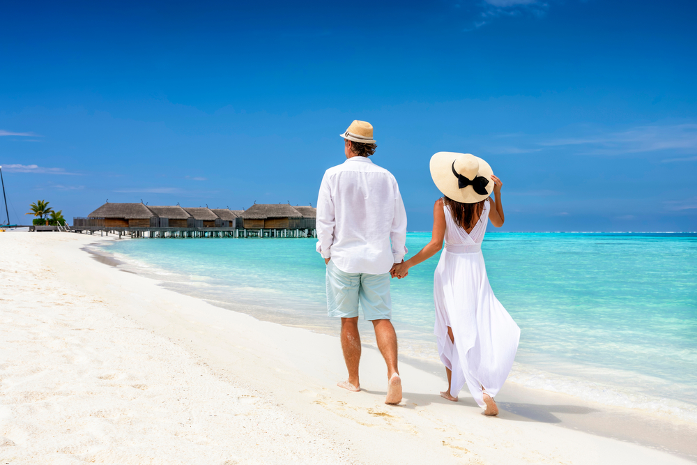 HappyCoupleInWhiteClothingAndWithHatsWalksDown | CuddlyNest Travel Blog