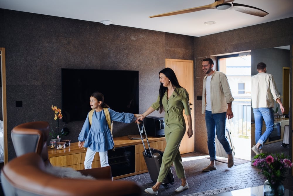 HappyYoungFamilyWithTwoChildrenEnetringRoomAtLuxury | CuddlyNest Travel Blog