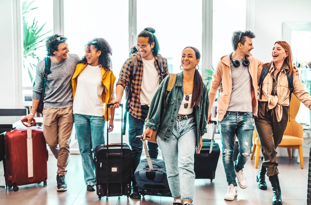 YoungGroupOfTouristsWithSuitcasesArrivingAtYouthHostel | CuddlyNest Travel Blog