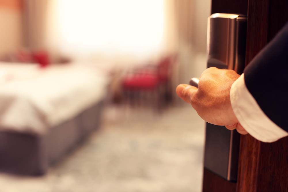 PictureShowingHandOfBusinessmanOpeningHotelRoom | CuddlyNest Travel Blog