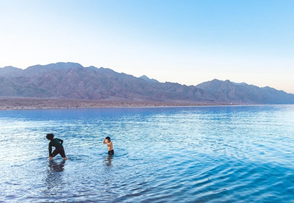 Children playing in the water at Haql Shipwreck Beach