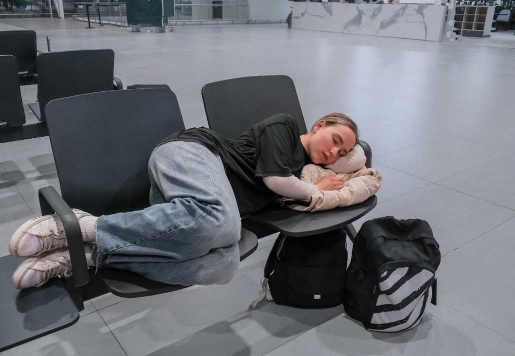 best-airports-to-sleep-in-woman-sleeping | CuddlyNest Travel Blog