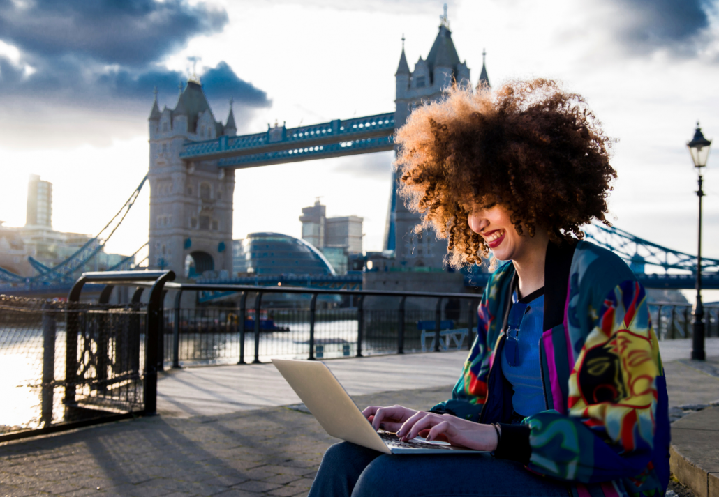 young-woman-sitting-outdoors-using-laptop-tower-bridge